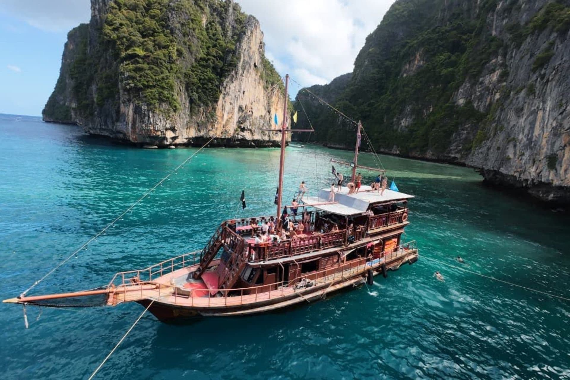 Aerial view of the Pirates ship anchored in emerald Pileh Lagoon ringed by cliffs
