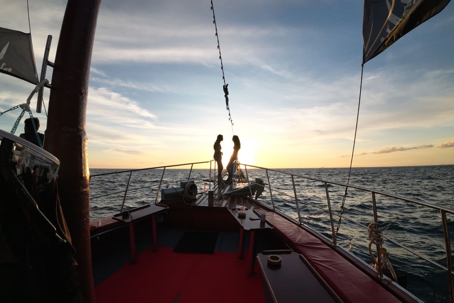 Silhouettes on the bow as the sun sets