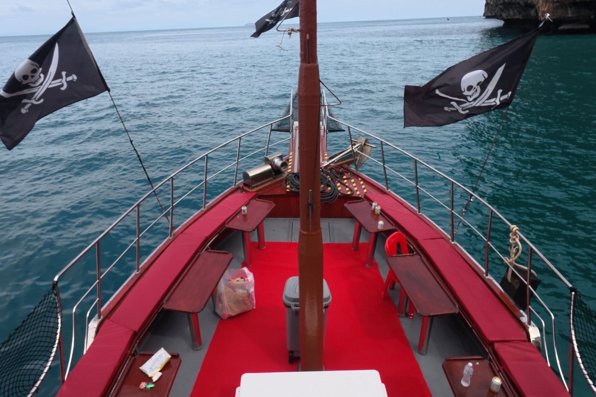Down the red foredeck past twin jolly rogers