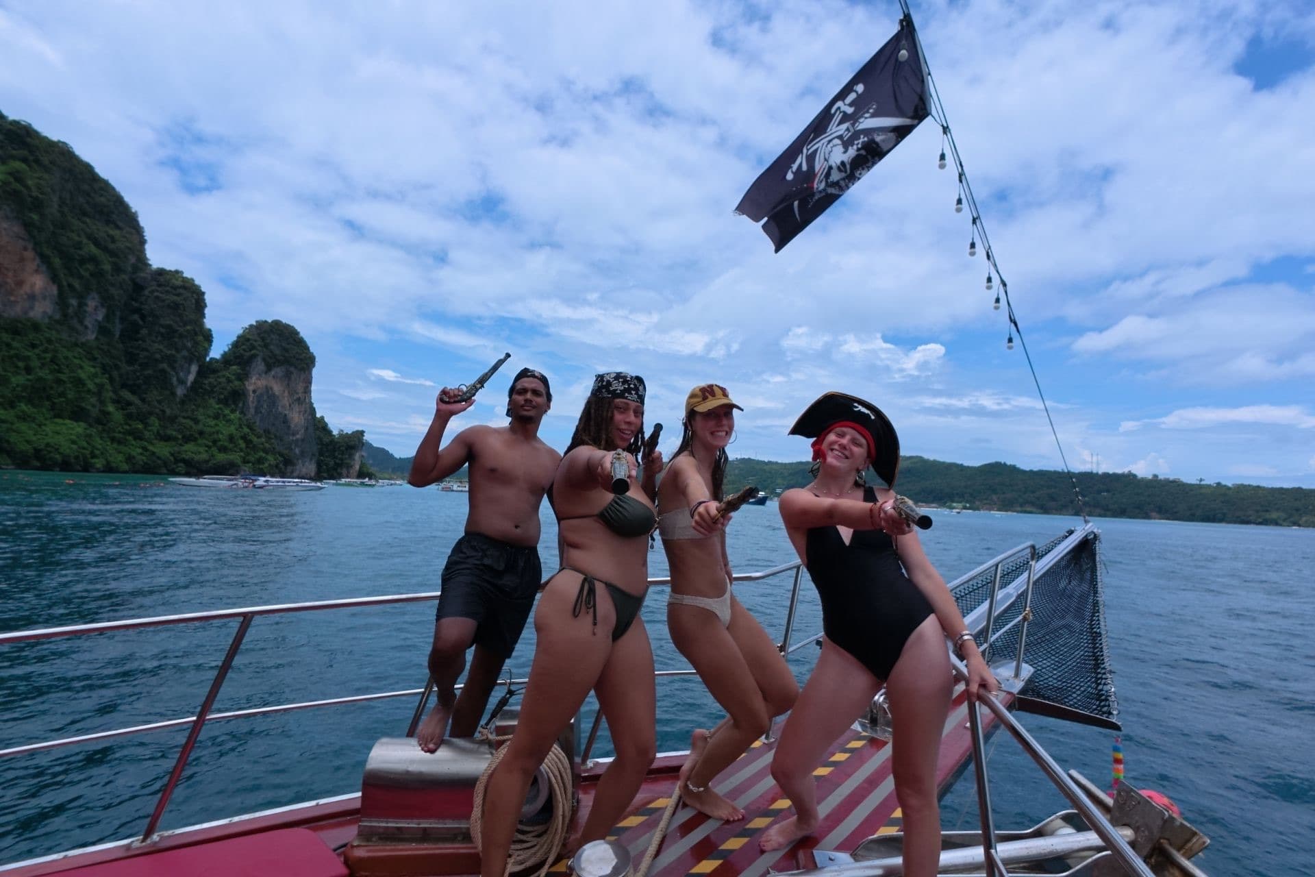 Crew in pirate hats with prop pistols on the bow